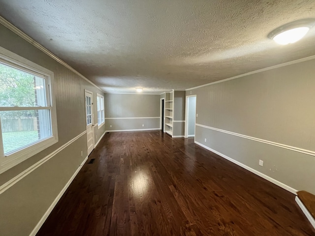 spare room featuring ornamental molding, a textured ceiling, and dark wood-type flooring