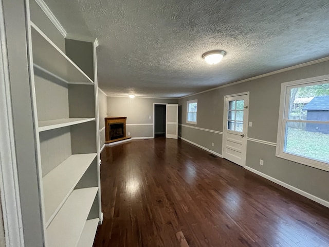 unfurnished living room with dark hardwood / wood-style floors, ornamental molding, and a textured ceiling