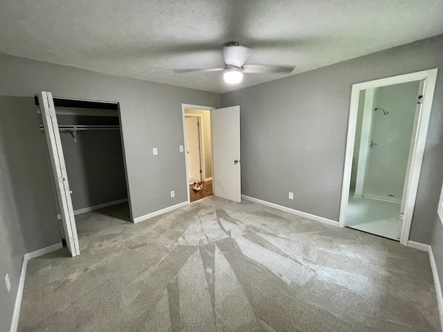 unfurnished bedroom with ceiling fan, a closet, light colored carpet, and a textured ceiling