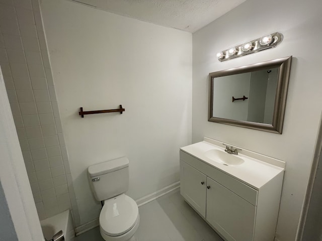 bathroom with a bathtub, vanity, a textured ceiling, and toilet