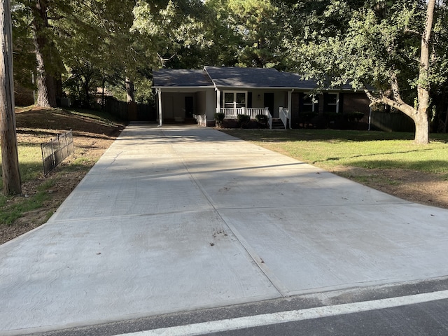 ranch-style house with a carport, a porch, and a front yard