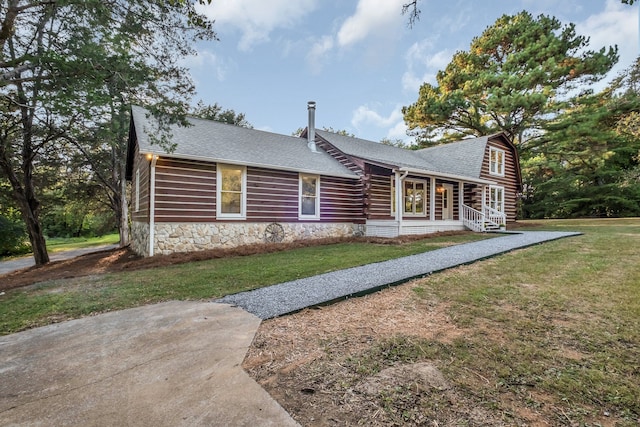 log home featuring covered porch and a front yard