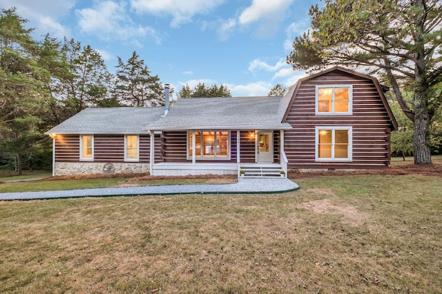 log-style house with covered porch and a front yard