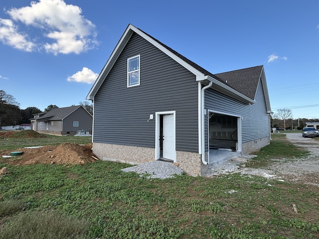 view of property exterior with a garage and a yard