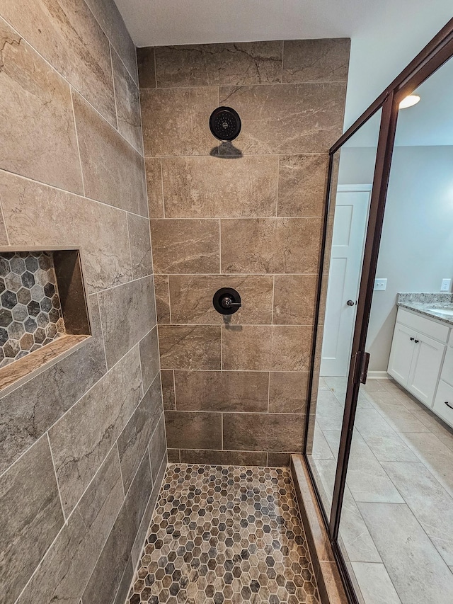 bathroom with vanity and tiled shower