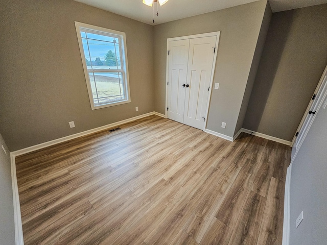 unfurnished bedroom with wood-type flooring and a closet