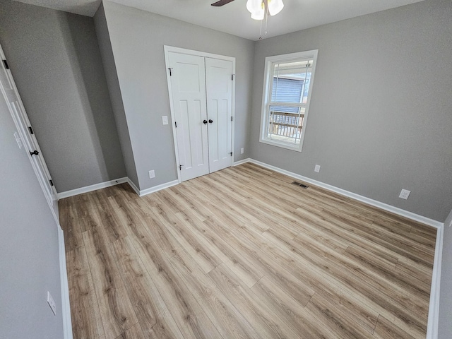 unfurnished bedroom with ceiling fan, a closet, and light wood-type flooring