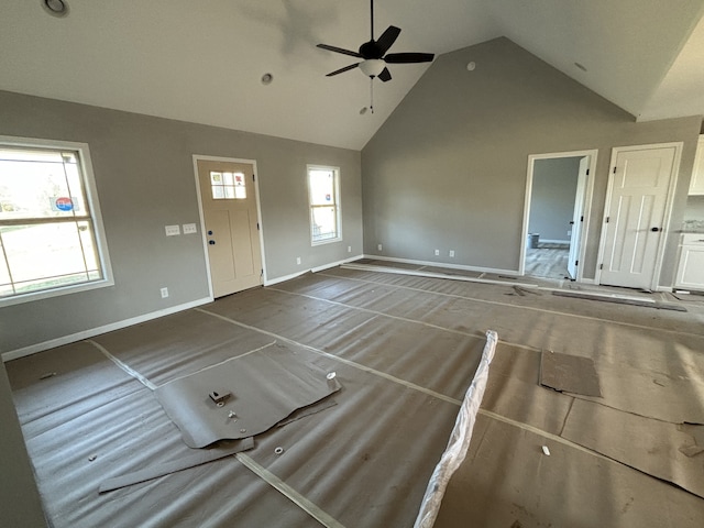 unfurnished living room with high vaulted ceiling and ceiling fan