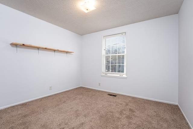 carpeted spare room with a textured ceiling