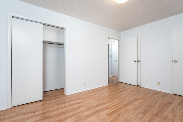 unfurnished bedroom with a textured ceiling and light wood-type flooring