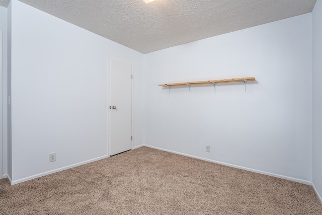 carpeted empty room with a textured ceiling