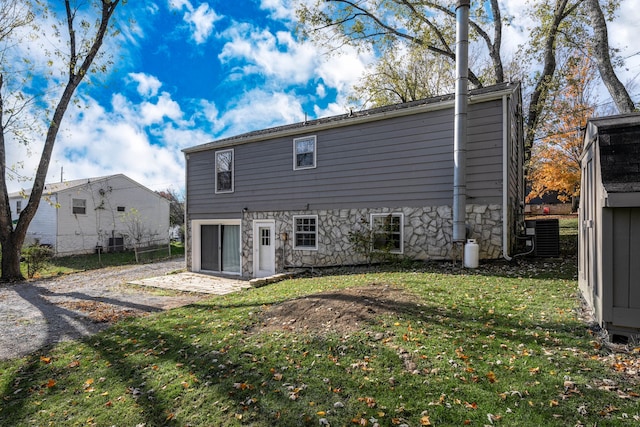 rear view of house with a yard and central AC unit