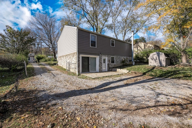 rear view of property with a storage unit