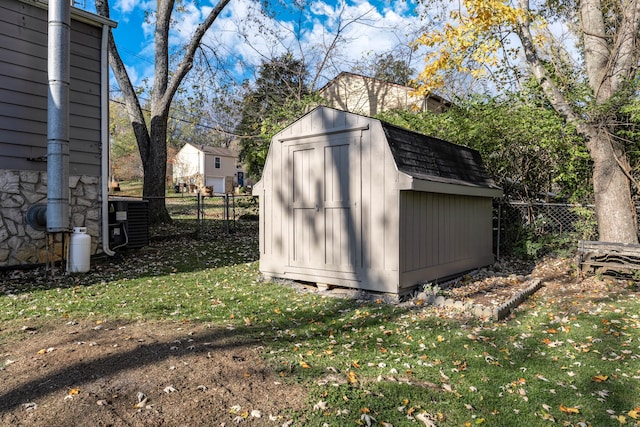 view of outdoor structure featuring central AC unit and a lawn