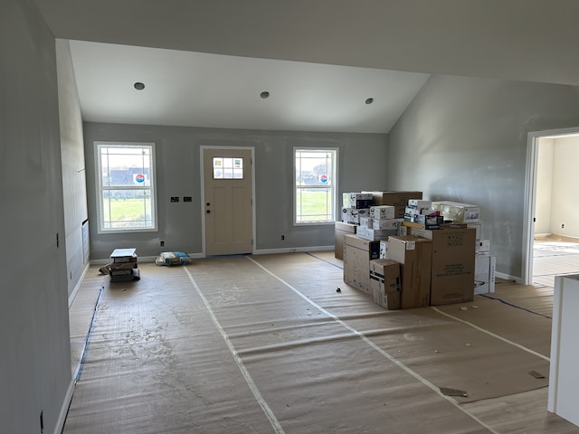 entrance foyer with baseboards and vaulted ceiling