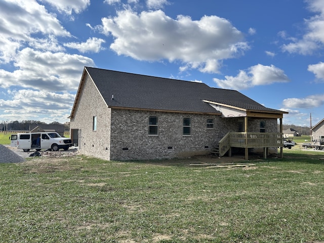 back of property featuring a wooden deck and a yard