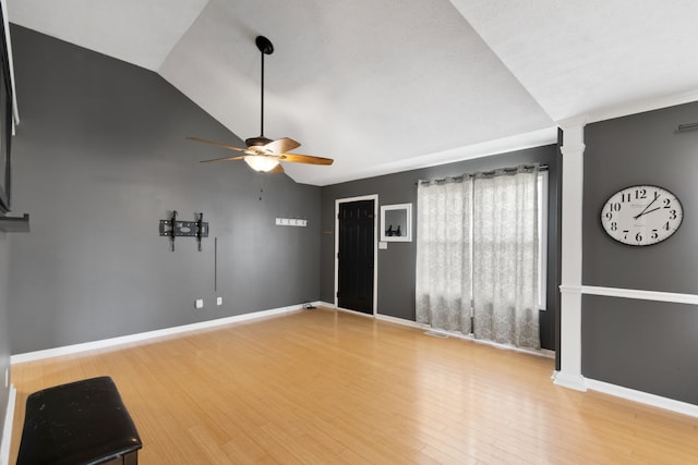 spare room featuring wood-type flooring, decorative columns, ceiling fan, and lofted ceiling