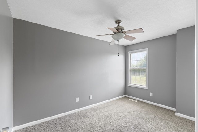 carpeted spare room with ceiling fan and a textured ceiling