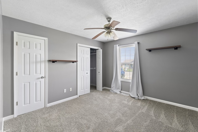 unfurnished bedroom featuring carpet, ceiling fan, and a textured ceiling