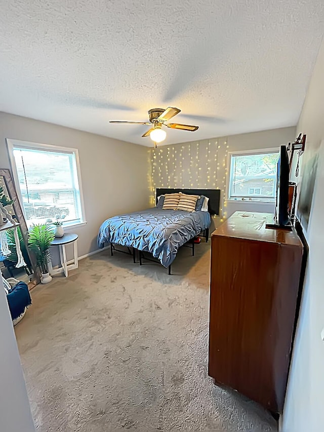 bedroom with carpet floors, wallpapered walls, ceiling fan, and multiple windows