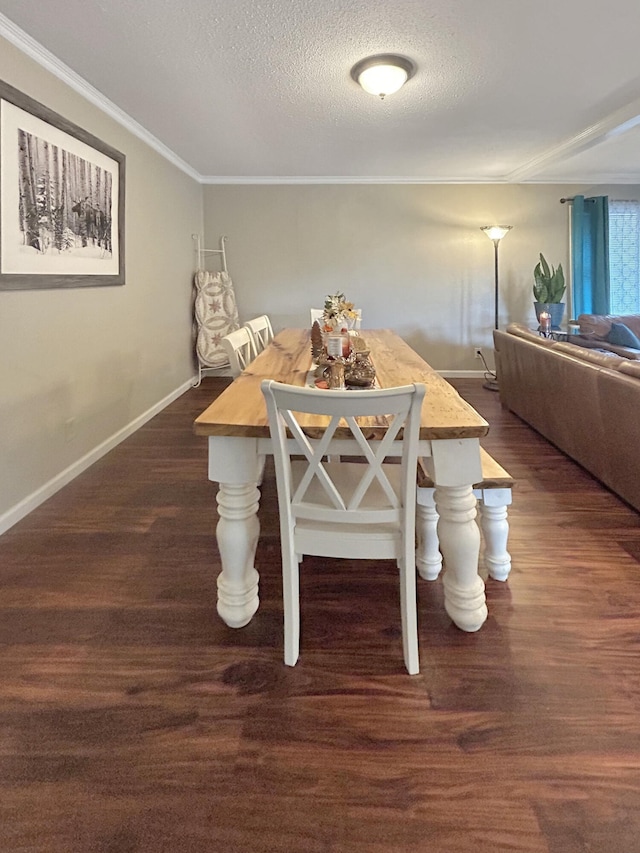 dining room with dark wood-style floors, crown molding, a textured ceiling, and baseboards