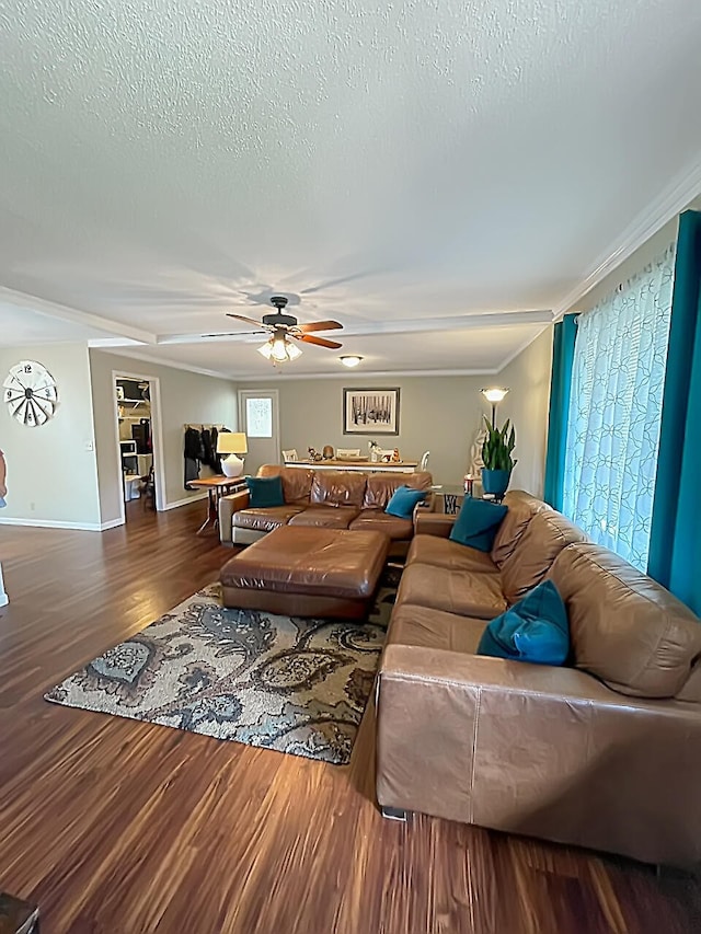 living area featuring baseboards, ceiling fan, wood finished floors, crown molding, and a textured ceiling