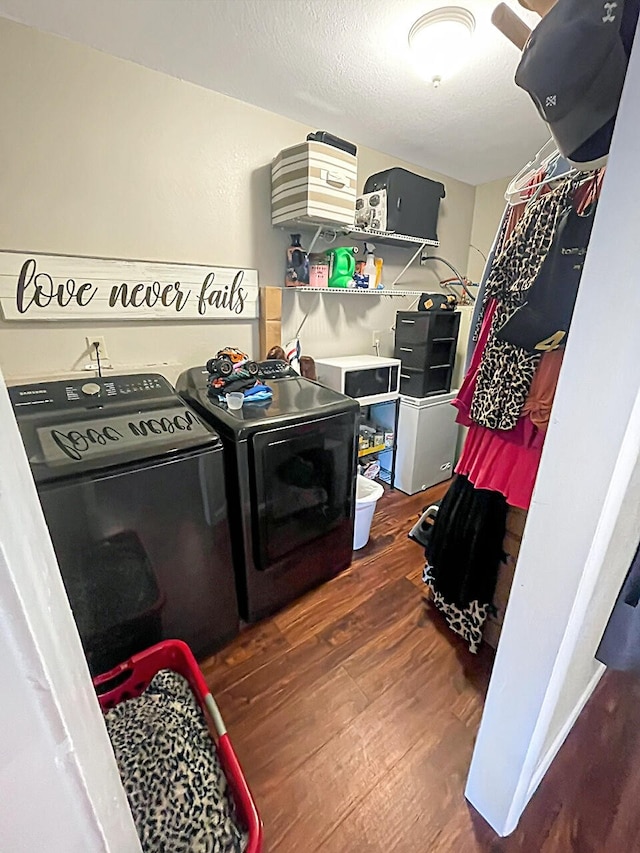 laundry room with a textured ceiling, laundry area, independent washer and dryer, and wood finished floors