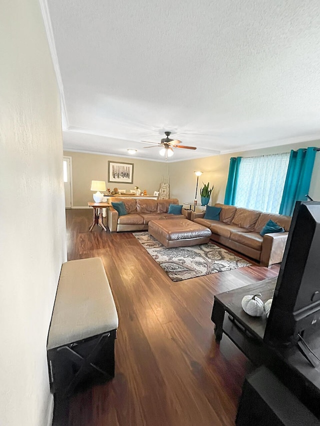 living room featuring ceiling fan, a textured ceiling, and wood finished floors