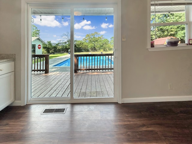 doorway with plenty of natural light, visible vents, and wood finished floors