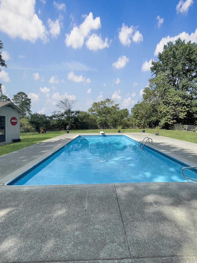 pool with a patio area and a yard