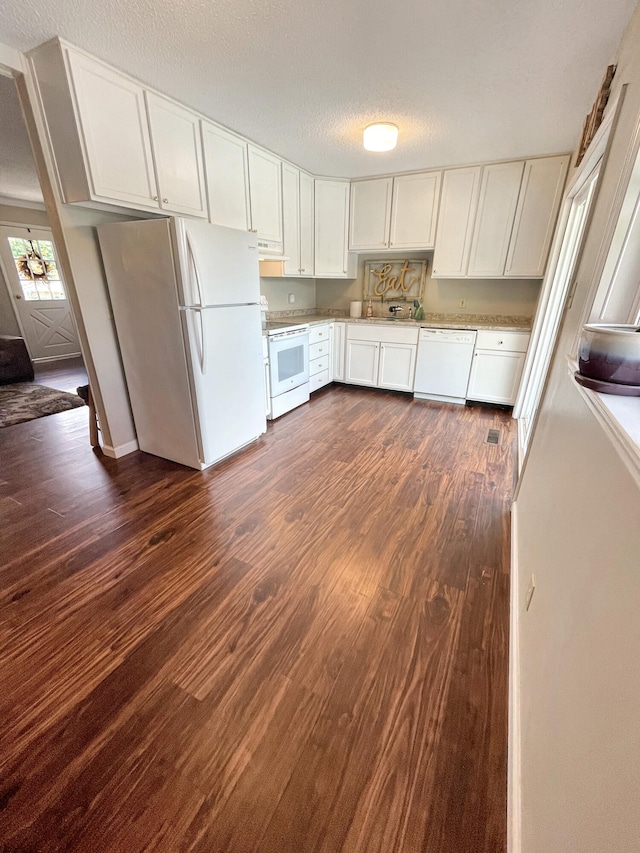 kitchen featuring white appliances, dark wood-style floors, light countertops, a textured ceiling, and white cabinetry