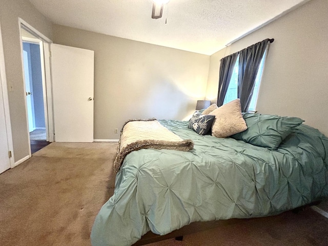 bedroom featuring a textured ceiling, carpet, a ceiling fan, and baseboards