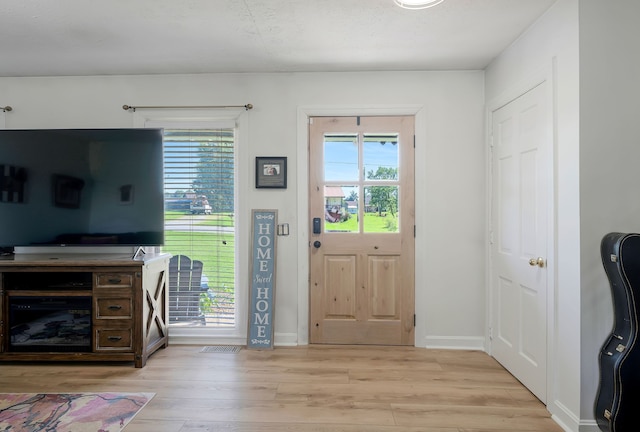 foyer entrance featuring light hardwood / wood-style flooring and a healthy amount of sunlight