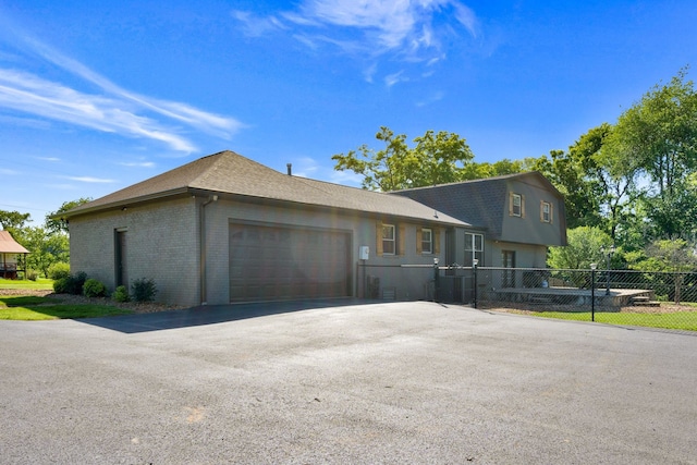 view of front facade featuring a garage and central air condition unit