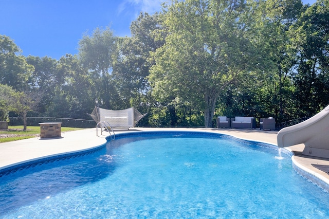 view of pool with a patio area and a water slide