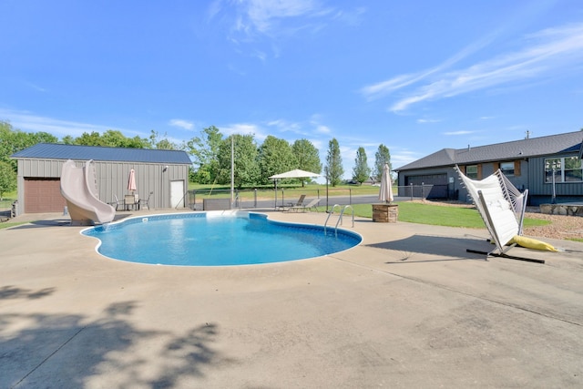 view of swimming pool with an outbuilding, a patio, and a water slide