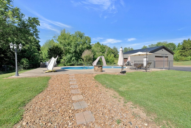 view of pool featuring a patio area, a yard, and a water slide