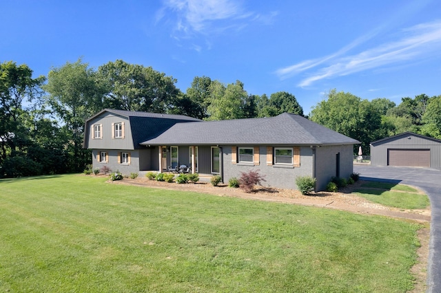 view of front of home with an outbuilding, a front yard, and a garage