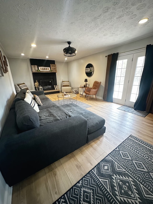 living room featuring hardwood / wood-style floors, a fireplace, and a textured ceiling