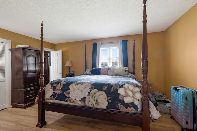 bedroom featuring light hardwood / wood-style floors and a textured ceiling