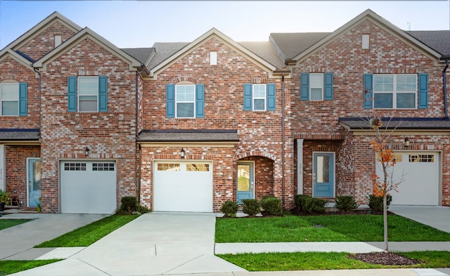 multi unit property with a garage and a front lawn