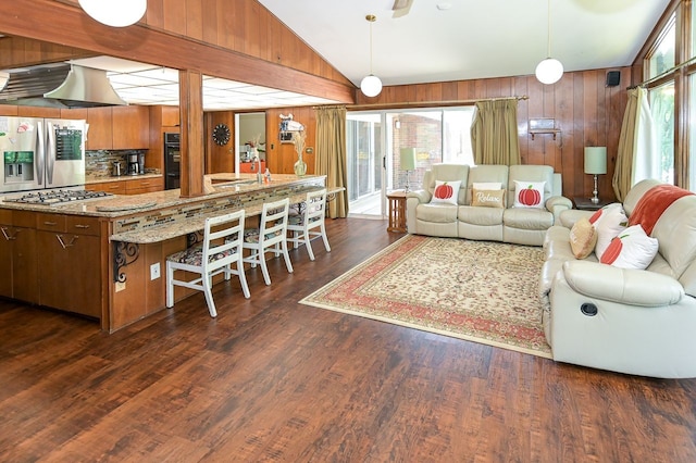 living room with dark hardwood / wood-style floors, lofted ceiling, and wooden walls