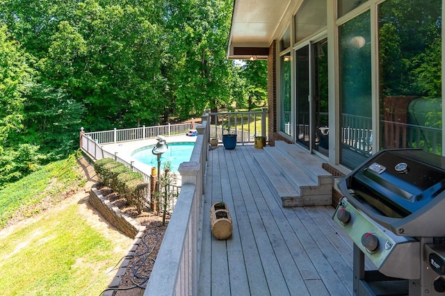 deck featuring a fenced in pool and grilling area