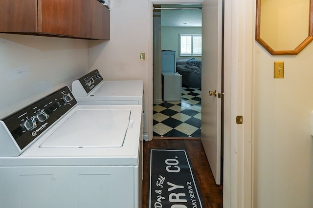 laundry area featuring cabinets, dark hardwood / wood-style floors, and independent washer and dryer