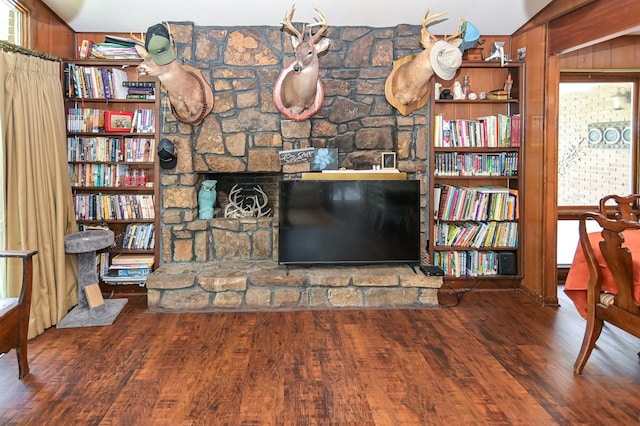 unfurnished living room featuring wood walls, wood-type flooring, and vaulted ceiling