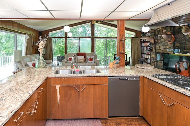 kitchen featuring dishwasher, plenty of natural light, wooden walls, and sink