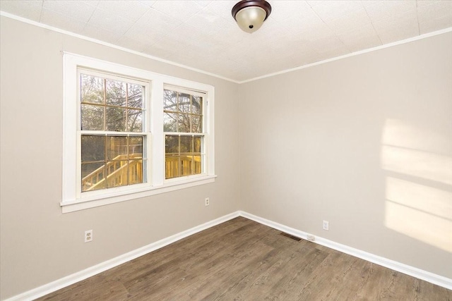 empty room with wood-type flooring and crown molding