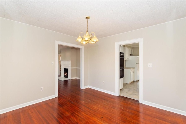 unfurnished room featuring dark hardwood / wood-style floors and an inviting chandelier