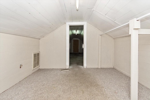 additional living space featuring light colored carpet and lofted ceiling