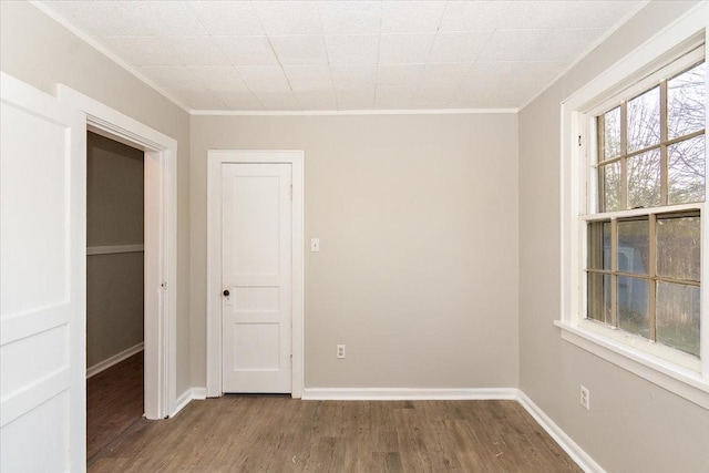 spare room with hardwood / wood-style flooring and crown molding